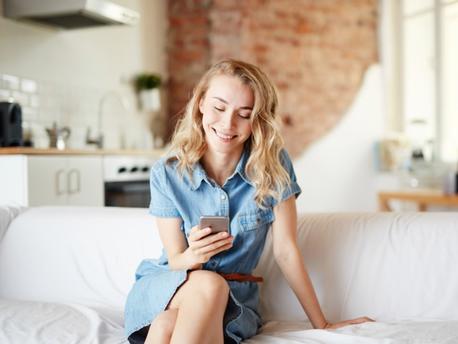 woman looking at her phone on couch