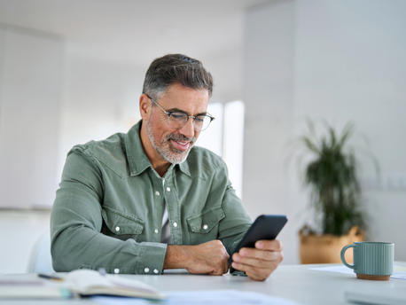man looking at his phone and plant