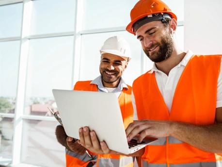 two construction guys looking at laptop