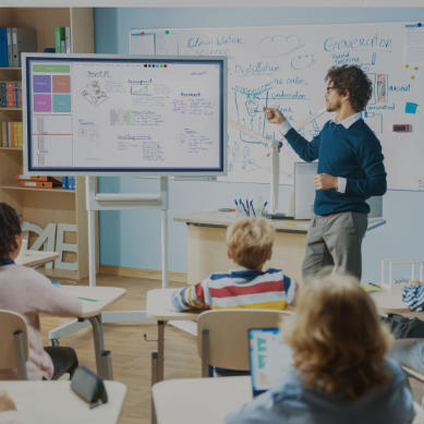 teacher in classroom with smart whiteboard tv