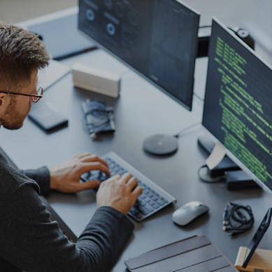man in office working and looking at screen and typing on keyboard